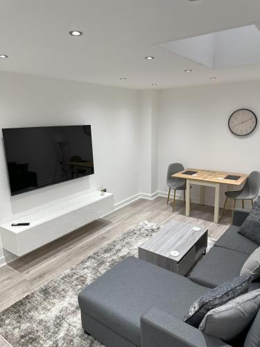 a living room with a large flat screen tv at Stylish City Retreat with Views & Court Yard in Leeds