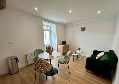 a living room with a table and chairs and a couch at Quiet apartment - Touraine in Sorigny