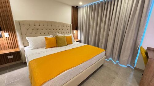 a bedroom with a large bed with yellow pillows at Belmonte 316-Apartamento luxury con pisicina en Av centenario in Armenia