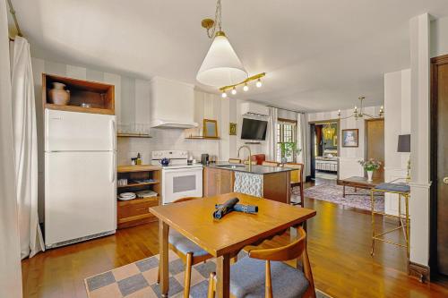 a kitchen with a table and a white refrigerator at Estello Suites & Spa in Lac-Mégantic