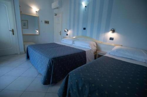 a hotel room with two beds in a room at Fly in Viareggio beach in front of the famous promenade with shops and establishments in Viareggio