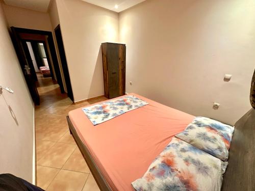 a small bedroom with a bed with orange sheets at Apartamentos Al Borj 3J إقامة البرج in Ifargane