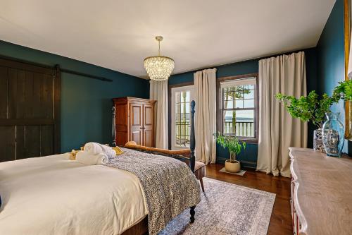 a bedroom with blue walls and a large bed at Estello Suites & Spa in Lac-Mégantic