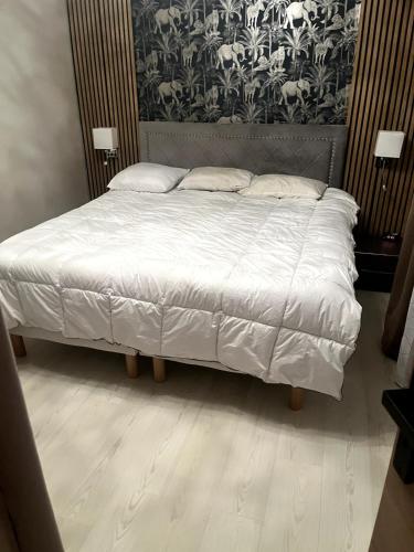 a bed with white sheets and pillows in a bedroom at Grand 2 pièces ensoleillé in Font-Romeu