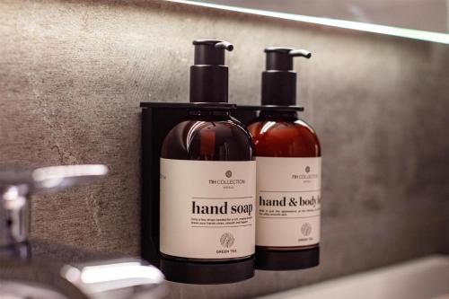 two bottles of wine sitting on a bathroom sink at NH Collection Andorra Palomé in La Massana
