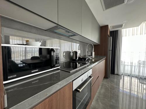 a kitchen with a counter top with a microwave at Grand Sapphire Luxury Residence By MyGuest Cyprus in Iskele