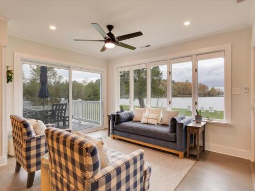a living room with a couch and chairs and windows at Dragonfly Cove in Mount Pleasant