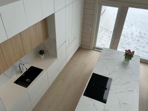una cucina bianca con bancone e lavandino di Villa Aurora Ryti a Rovaniemi