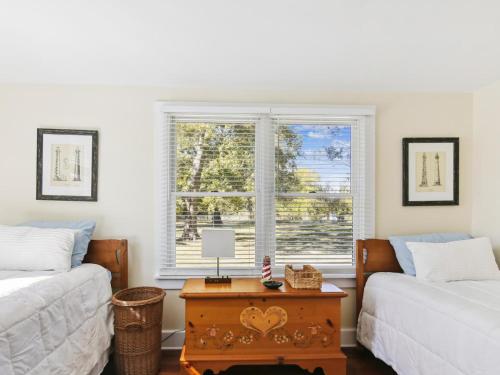 a room with two beds and a table with a window at Crepe Myrtle in Tilghman