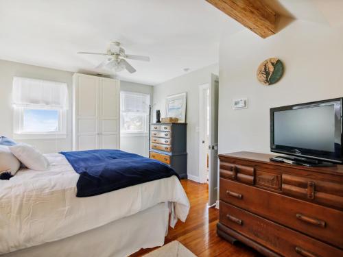 a bedroom with a bed and a flat screen tv at Crepe Myrtle in Tilghman