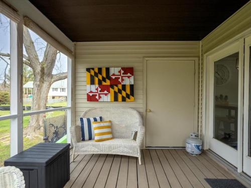 a porch with a chair and a bench and a painting at Down By The Docks in Oxford