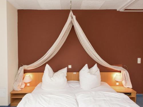 a bedroom with a bed with white sheets and pillows at Majestic Stay in Deutschneudorf in Deutschneudorf