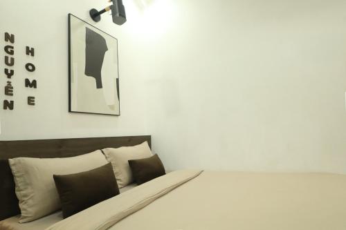 a bedroom with a bed and a picture on the wall at Nguyen's Home Saigon Airport in Ho Chi Minh City