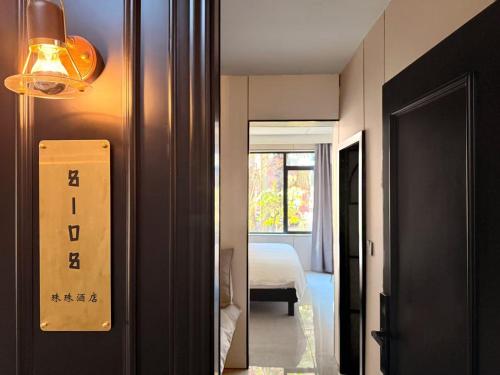a hallway with a room with a bed and a light at Shanghai Zhuzhu Hotel - 24-hour free airport pick-up and drop-off at Pudong Airport in Shanghai