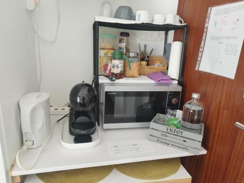 a kitchen counter with a coffee maker and a microwave at Alexia Room in Funchal