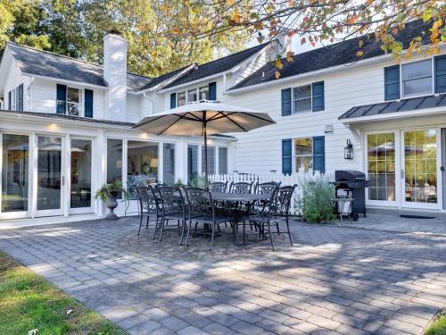a patio with chairs and an umbrella in front of a house at Captains Cove in Saint Michaels