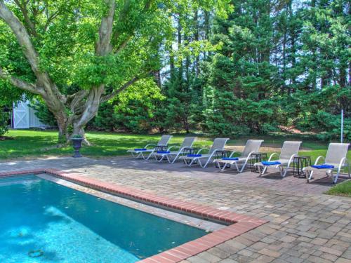 a group of chairs sitting next to a swimming pool at Captains Cove in Saint Michaels
