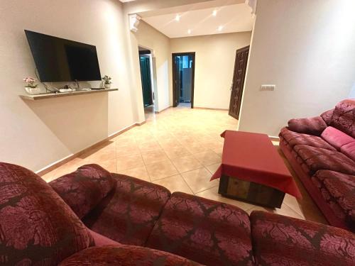 a living room with two couches and a tv at Apartamentos Al Borj 3J إقامة البرج in Ifargane