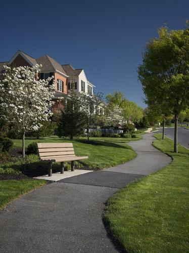 a park bench sitting on the side of a sidewalk at Cozy Stay 2min to DT Cincinnati & UC Medical Center in Cincinnati