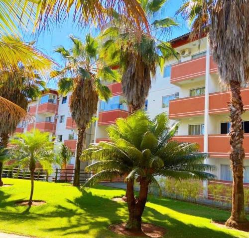 a group of palm trees in front of a building at PONTAL DO LAGO FLAT - Lucas in Caldas Novas