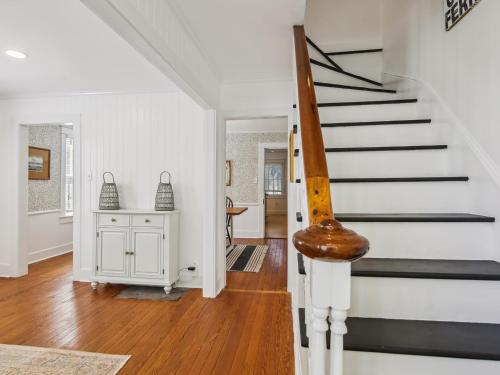 a staircase in a home with white walls and wooden floors at Eventide of Oxford in Oxford