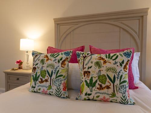 a bed with four pillows and a headboard at Namaste on the Bay in Stevensville