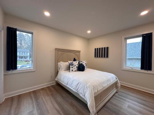 a bedroom with a bed and two windows at Namaste on the Bay in Stevensville