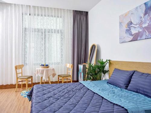 Gò CôngLà lá 1 Vinhome Grand Park的一间卧室配有蓝色的床和桌椅