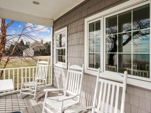 two white chairs sitting on the porch of a house at Ferry View in Oxford
