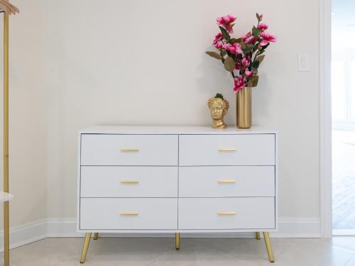 a white dresser with a vase of flowers on top at Namaste on the Bay in Stevensville