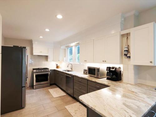 a kitchen with white cabinets and a black refrigerator at Sailor Joes in Sherwood