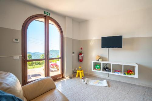 sala de estar con ventana grande y TV en Babyaccommodation Family Hills II, en Tovo San Giacomo