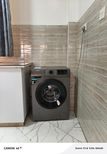 a washing machine in a corner of a bathroom at The pine 1 bedroom house California plaza in Nanyuki
