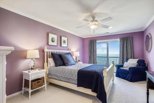 a bedroom with purple walls and a bed and a chair at The Birds Nest in Madison