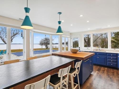 a kitchen with blue cabinets and a large island with chairs at Mill Point in Neavitt
