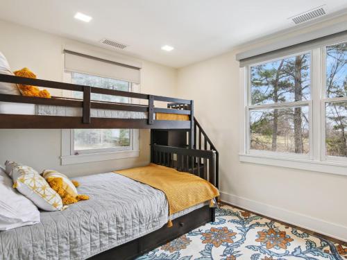 a bedroom with a bunk bed and two windows at Mill Point in Neavitt