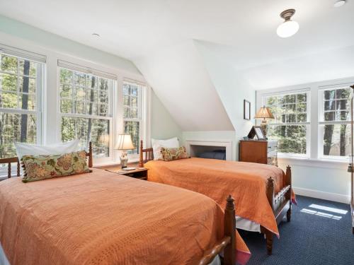 two beds in a room with large windows at The Water House in Saint Michaels