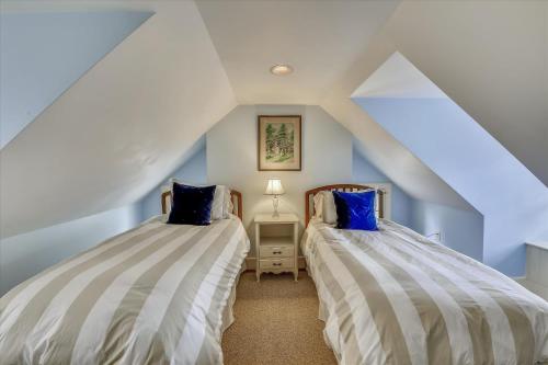 two beds in a attic bedroom with blue walls at Thornton in Kennedyville