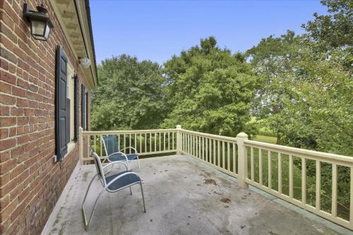 a balcony with two chairs and a fence at Thornton in Kennedyville