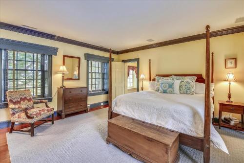 a bedroom with a bed and a chair and windows at Thornton in Kennedyville