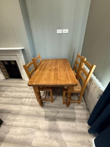 a wooden table and chairs in a room with a fireplace at Bolton Road Apartments in Eastbourne