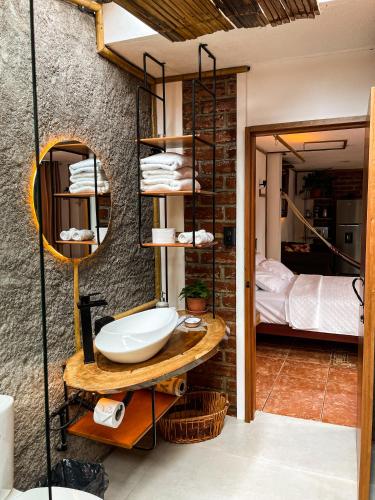 Un baño con lavabo y una cama en una habitación. en Raíces y Refugio, en Puyo