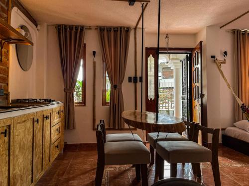 a kitchen with a table and chairs in a room at Raíces y Refugio in Puyo