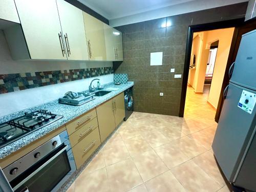 a kitchen with a stove and a sink and a refrigerator at Apartamentos Al Borj 3J إقامة البرج in Ifargane