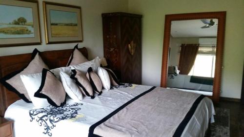 a bedroom with a large bed with many pillows at Beautiful Mountain View Aptt in Islamabad