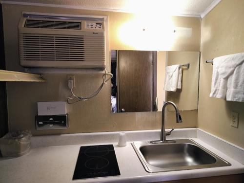 a kitchen with a sink and a air conditioner at 1st Interstate Inn in Sterling