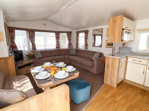 a living room with a table in a caravan at 21 Poplar Avenue in Felixstowe