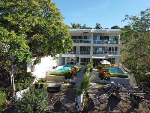 a large building with a swimming pool in front of it at Casa Blanca #1 Beautiful modern beach house in Sámara