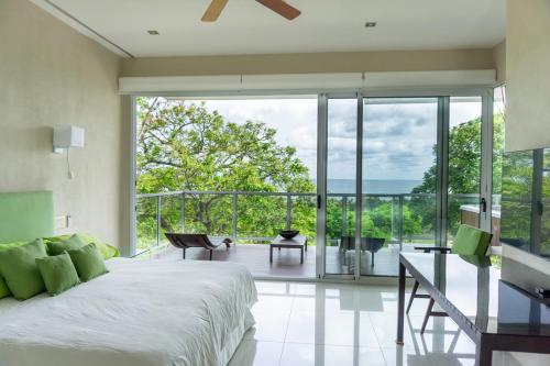 a bedroom with a large bed and a balcony at Casa Blanca #1 Beautiful modern beach house in Sámara
