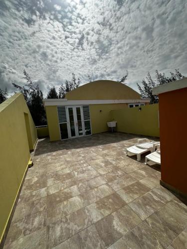 a building with a large patio with a cloudy sky at Beach Front Penthouse in Loiza